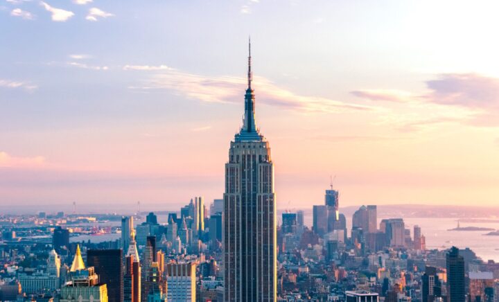 The Empire State Building, seen from above, stands tall amidst the surrounding skyscrapers in New York City