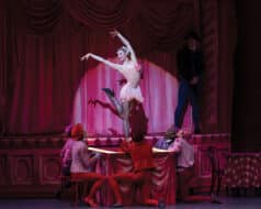 A woman dressed in pink is performing ballet in the musical theater show titled 'New York City Ballet'