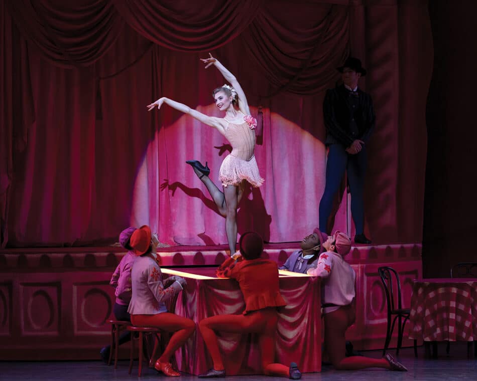 A woman dressed in pink is performing ballet in the musical theater show titled 'New York City Ballet'