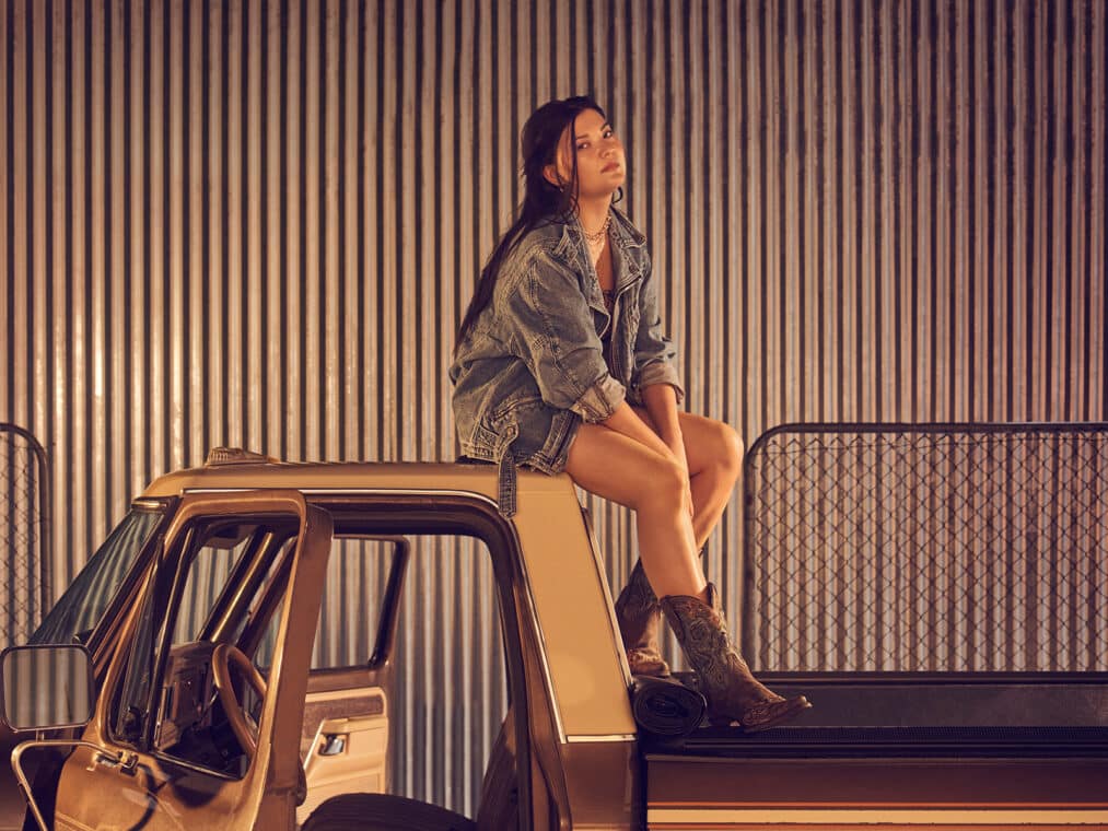 A woman sitting on top of a car roof in the performance of 'Carmen' at the Metropolitan Opera House