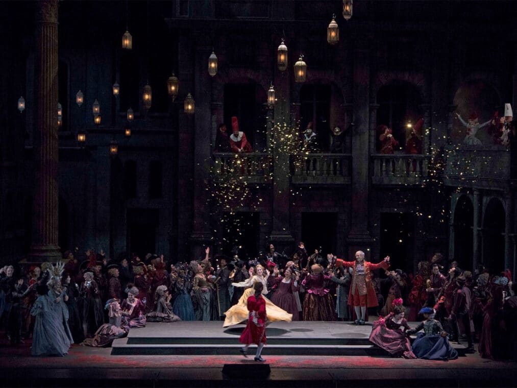 A performance set in a royal backdrop adorned with ornate lamps, titled 'Romeo et Juliette' at the Metropolitan Opera House