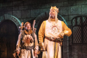 Two men are playing the roles of a king and a guard in a show 'Spamalot' at the St. James Theatre