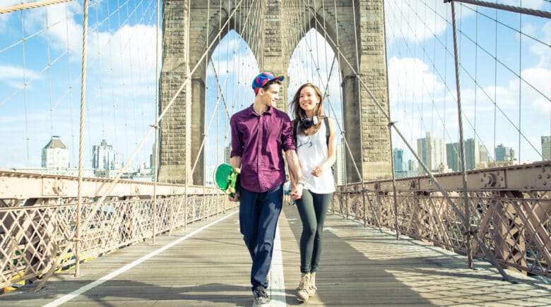 Young couple walking on the brooklyn bridge