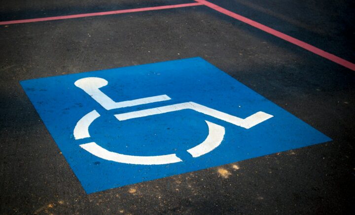 A disability symbol depicting a person in a blue and white wheelchair printed on the road