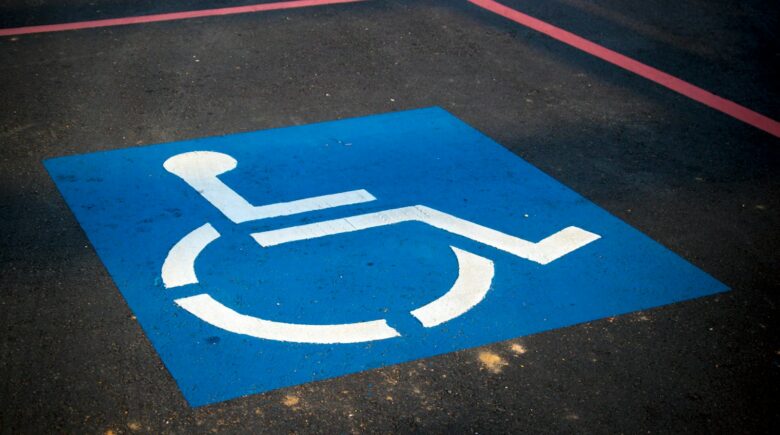 A disability symbol depicting a person in a blue and white wheelchair printed on the road