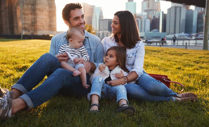 young-family-with-two-daughters-sitting-on-lawn-in-NYC