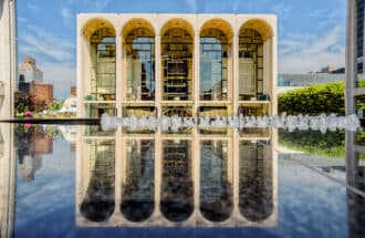 The Metropolitan Opera House reflected on the marble fountain of the Lincoln Square