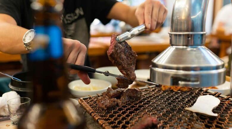 The experience of Korean BBQ in Flushing, with a diner grilling meat at their table