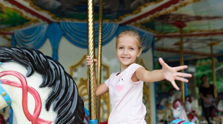 a girl enjoying a carousel ride in NYC