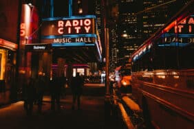 Radio City Music Hall in New York, with passersby and neon lights at night
