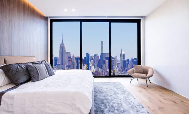 Modern and luxurious bedroom of minimalist interior design, with views of midtown New York skyline. Upscale condo or Hotel accommodation in NYC.