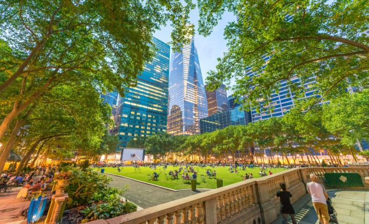 People relaxing in Bryant park on a sunny afternoon with skyscrapers in the backgroup. Manhattan, New York City