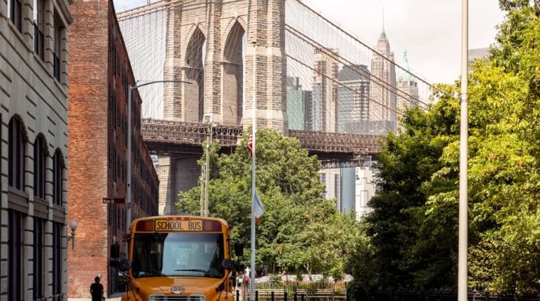 A yellow school bus is parked in Dumbo