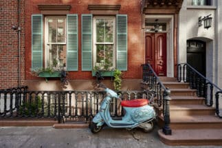 A brownstone building with a vintage scooter in Manhattan