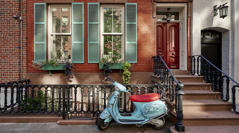 A brownstone building with a vintage scooter in Manhattan