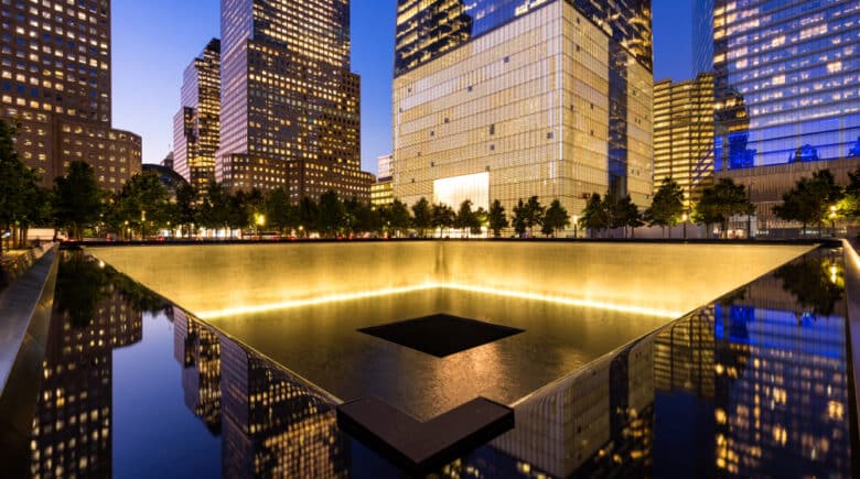 The North Reflecting Pool illuminated at twilight with view of One World Trade Center