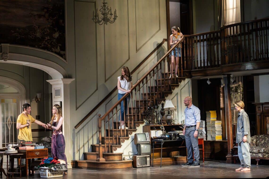 Scene from Appropriate with actors positioned on stairs and stage in a cluttered living room