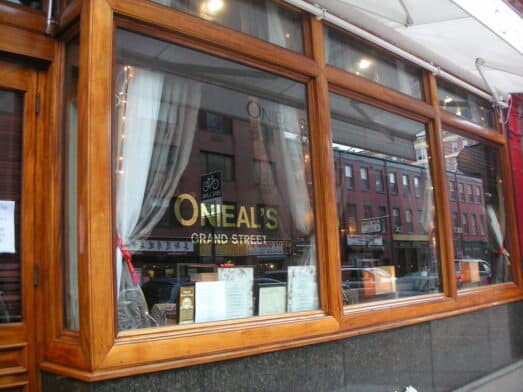 The glass window of Onieal's Grand Street, with the word Onieal's written in orange on the window