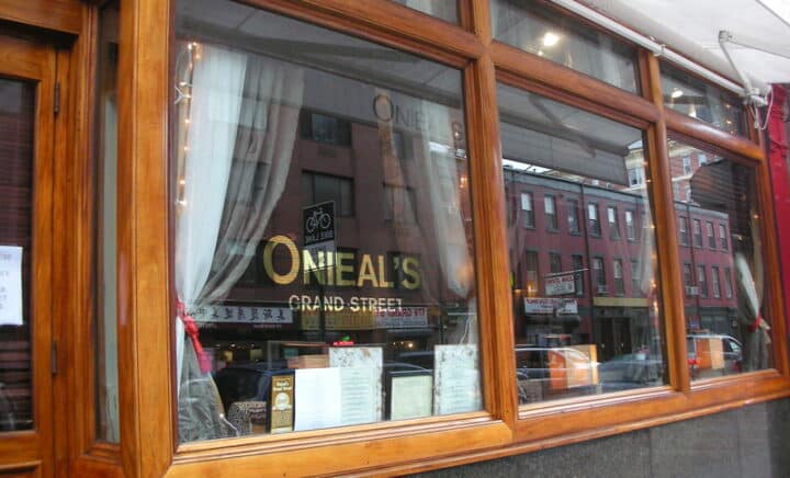 The glass window of Onieal's Grand Street, with the word Onieal's written in orange on the window