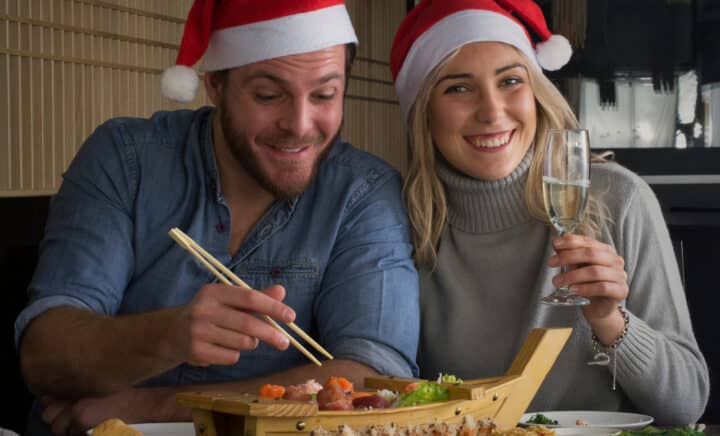 A couple wearing Christmas hats enjoying holidays on a boat cruise