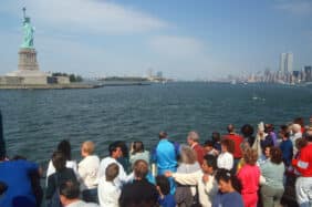 ourists viewing Statue of Liberty from the Circle Line boat tour of Ellis Island, New York