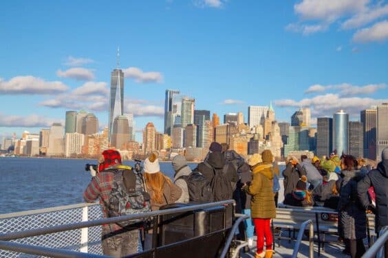 People were taking photos to capture the moment of the Manhattan buildings from the river while on a cruise ship