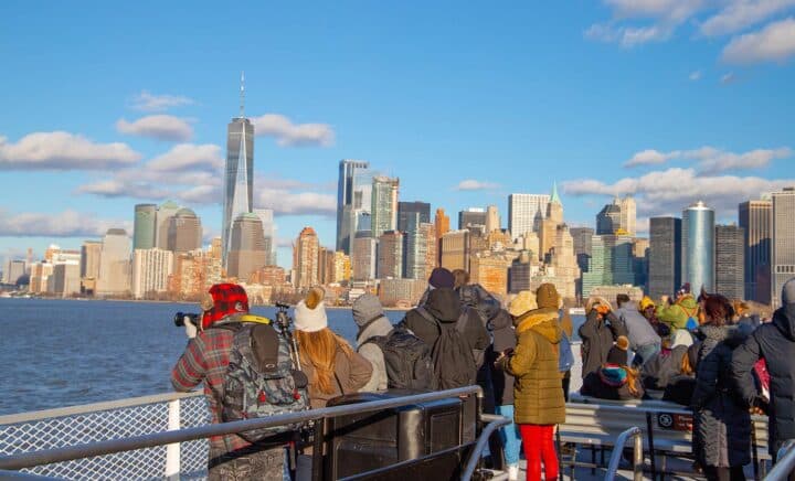 People were taking photos to capture the moment of the Manhattan buildings from the river while on a cruise ship