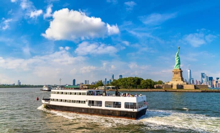 Statue of Liberty and tourist ship ferry in New York City