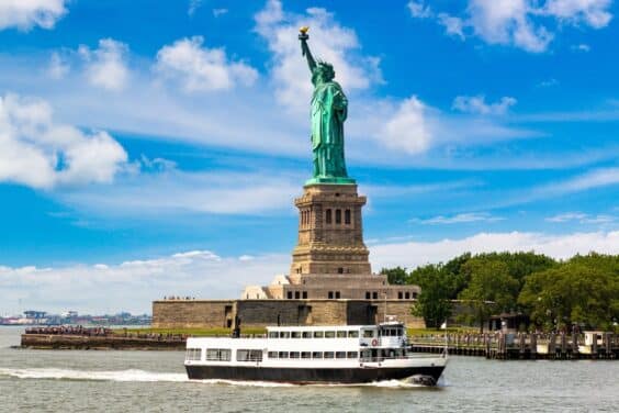 Statue of Liberty and tourist ship ferry in New York City, NY