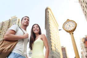 Tourists visiting New York city standing in front of Flatiron building