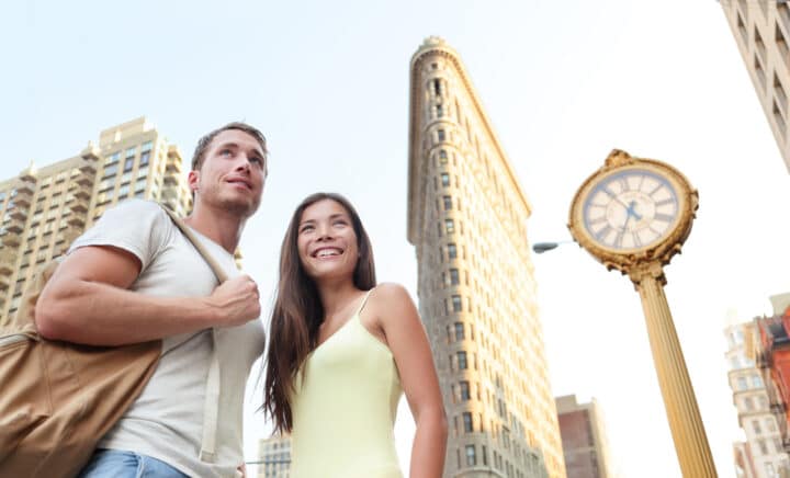 Tourists visiting New York city standing in front of Flatiron building