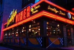 The Brooklyn Diner glows in twilight. The diner offers typical American fare and, despite its name, is located in Manhattan