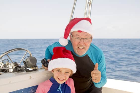 Father and daughter pose for the camera while enjoying a boat holiday at christmas