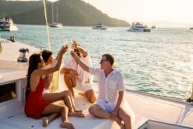 A group of friends enjoying a sunset on a sailboat tour