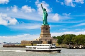 Statue of Liberty and tourist ship ferry in New York City