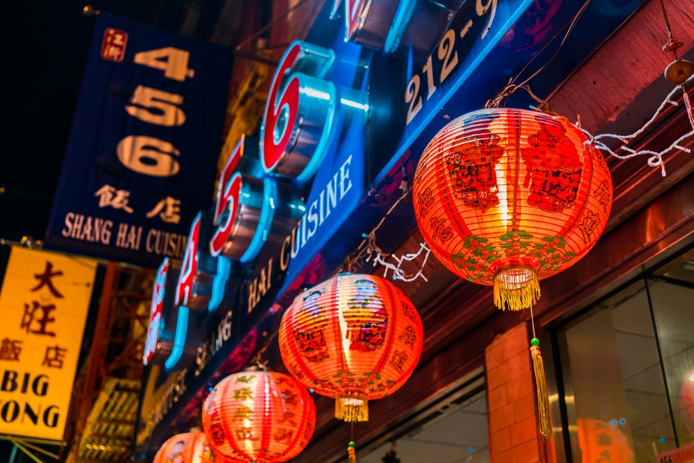 NYC Chinatown at night with paper lanterns and neon signs.