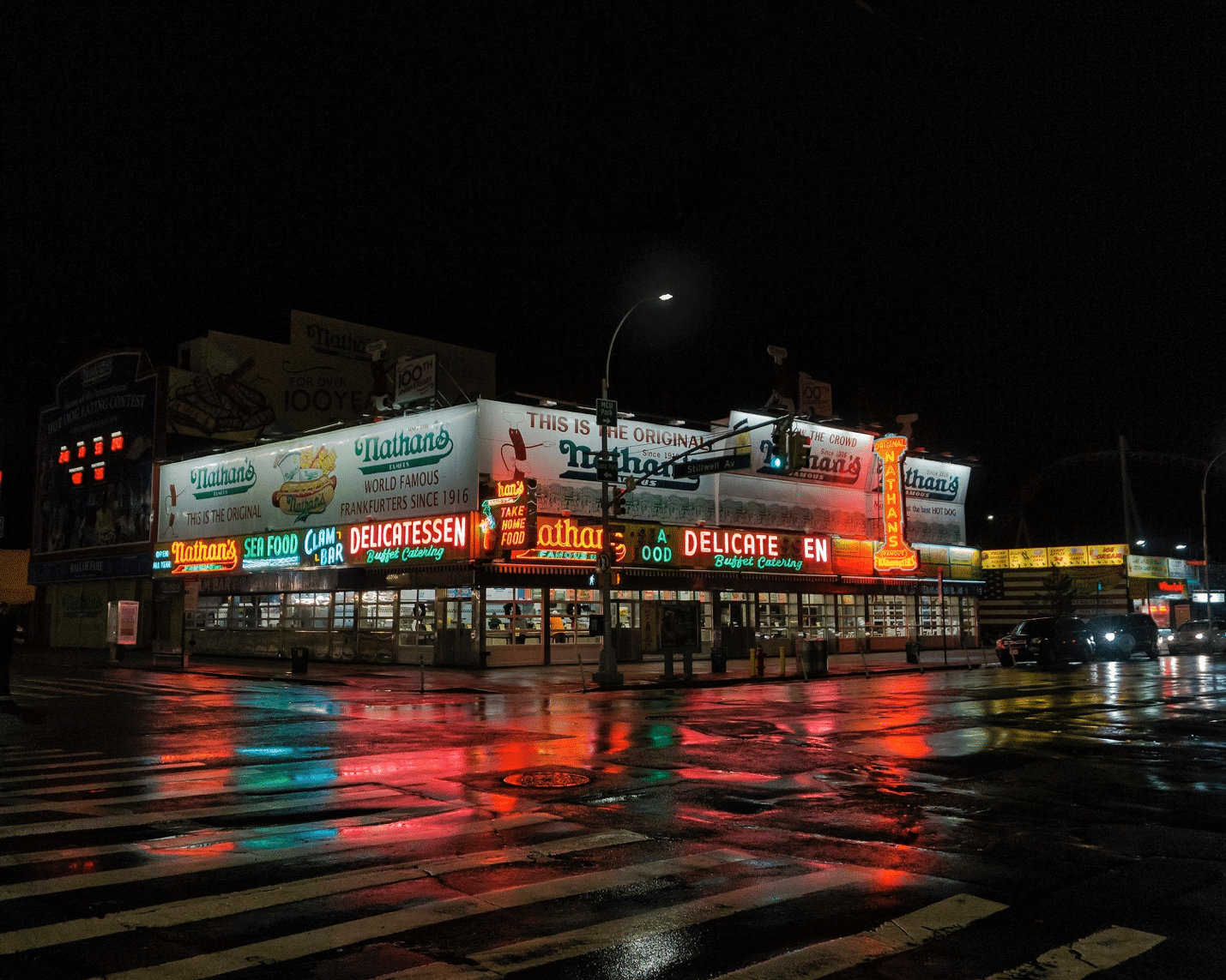 A food street at night, illuminated by colorful lights