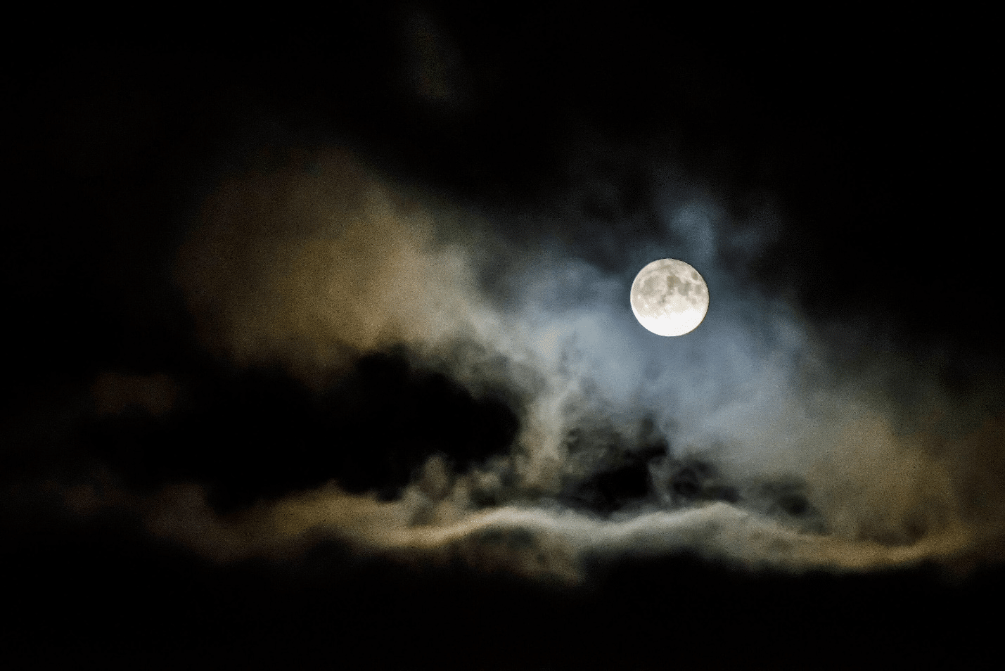 An image of a full moon and a light cloud.