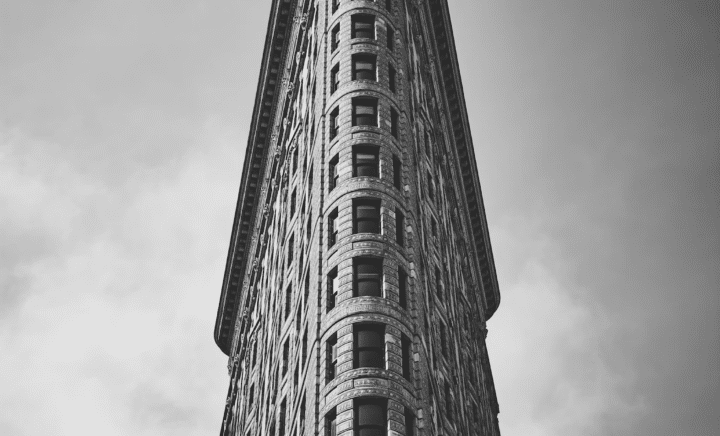 The iconic Flatiron Building in New York City, known for its unique triangular shape.