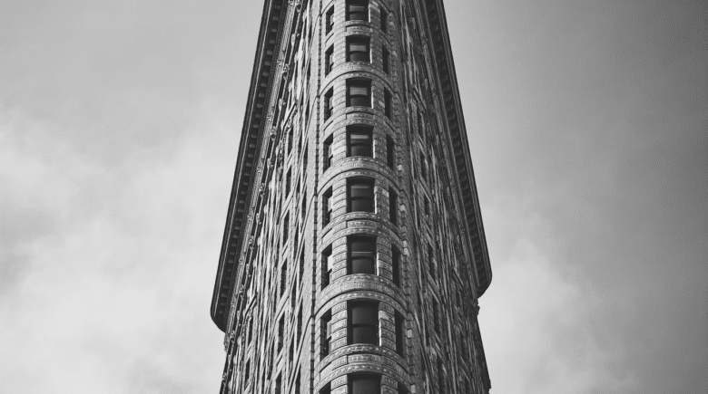 The iconic Flatiron Building in New York City, known for its unique triangular shape.