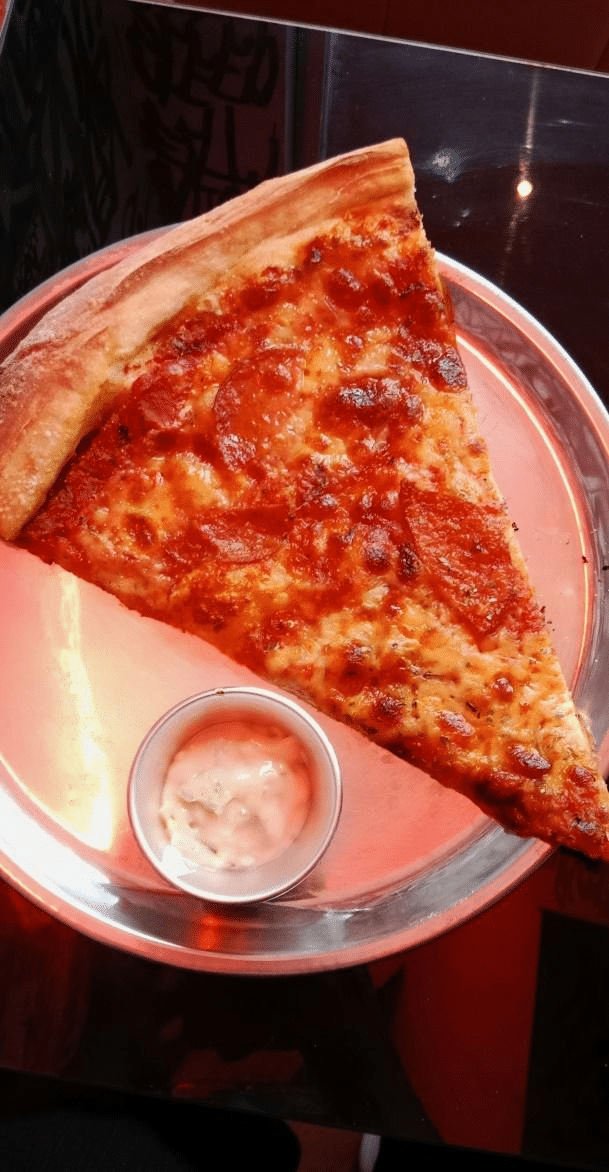 A classic slice of cheese pizza with a crispy crust, fresh tomato sauce, and melted mozzarella cheese from a New York City pizzeria.