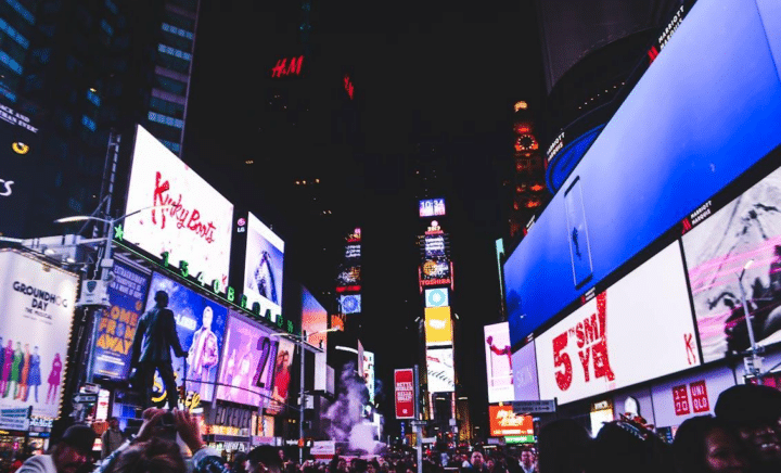 Illuminated Broadway district in New York City at night, showcasing bright lights and marquee signs