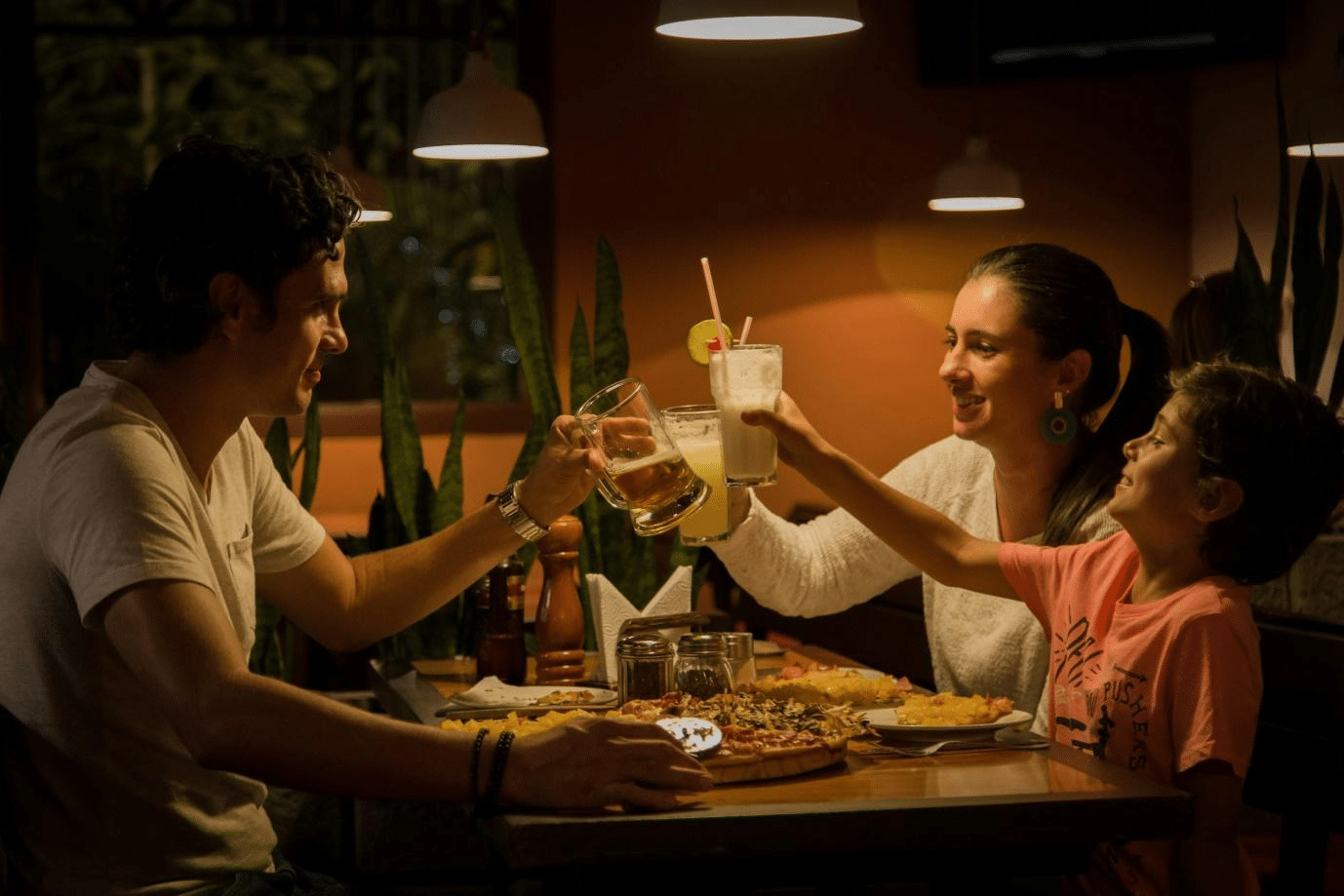 A family happily enjoying a meal together at a restaurant in New York City