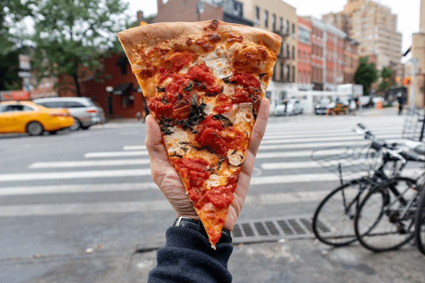 A person holding pizza during a one-day sightseeing tour