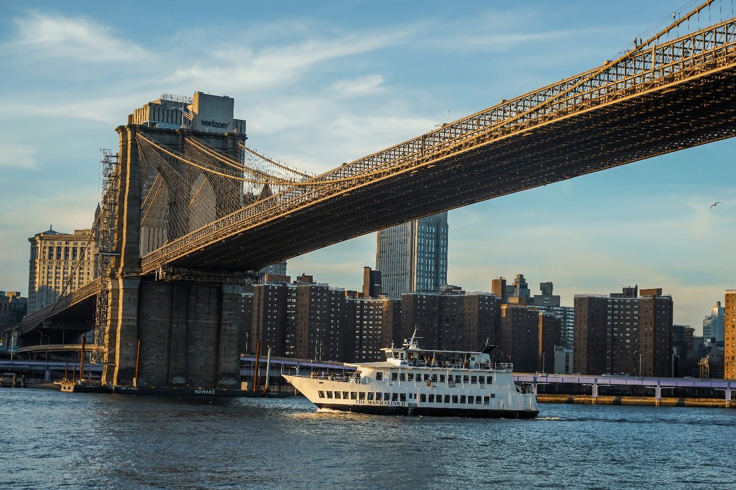 A boat passing under a bridge during a city trip to New York