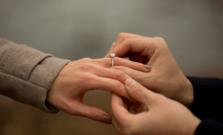 A man putting a ring on a woman’s finger during a New York City travel guide