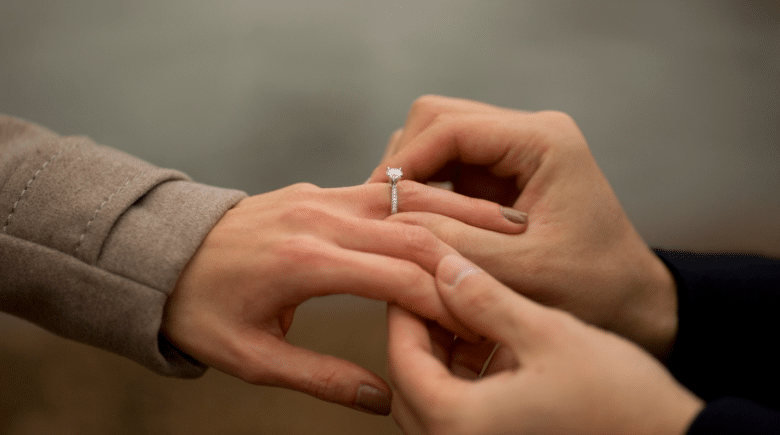 A man putting a ring on a woman’s finger during a New York City travel guide