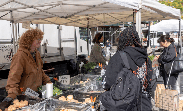 People at a market during a New York City travel guide