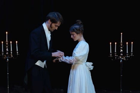 Two Broadway performers holding hands while making eye contact