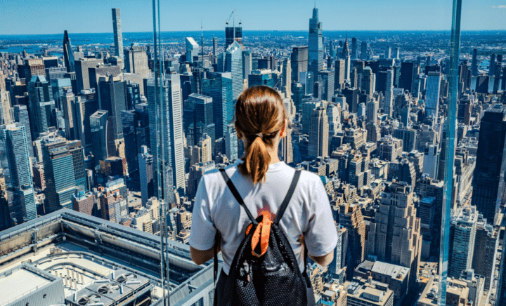 A person admiring the New York City skyline from an observation deck